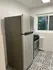 Modern kitchen corner with sleek stainless steel appliances and stylish patterned tile flooring, offering a bright and airy atmosphere.