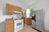 Modern kitchen with sleek stainless steel refrigerator, gas stove, and natural wood cabinetry, offering a bright and functional space.