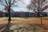Charming apartment building with classic brick facade surrounded by lush autumn scenery and mature trees.