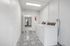 Modern laundry room with stylish patterned tiles, bright lighting, and efficient washer and dryer units.