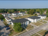 Aerial view of a charming apartment complex with neatly arranged buildings, ample parking, and lush green surroundings.