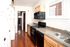 Bright and inviting kitchen with sleek countertops, modern black appliances, and white cabinetry, offering ample storage and natural light.