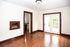 Bright and inviting room with polished hardwood floors, classic dark wood trim, and elegant French doors opening to natural surroundings.