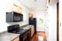Bright and inviting galley kitchen with modern appliances, wood cabinetry, and a windowed view, highlighting functionality and style.
