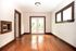 Bright and inviting empty room with elegant hardwood flooring, large windows, and stylish French doors leading to a lush garden view.