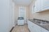 Cozy, bright kitchen featuring modern white cabinets, a dual sink, and a compact stove.