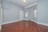 Bright and spacious room with elegant hardwood floors, soft gray walls, and ample natural light, ideal for creating a warm and inviting living space.