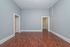 Bright and inviting room with sleek hardwood flooring, soft gray walls, and elegant white trim, offering a contemporary and versatile space.