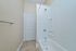 Modern bathroom with white bathtub and bright accents, featuring sleek fixtures and elegant tiling.