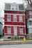 Charming red brick townhouse featuring classic architectural details and inviting curb appeal, perfect for urban living.
