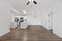 Modern open-concept kitchen and dining area with sleek white cabinets, stainless steel appliances, and elegant wood flooring.