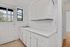 Bright and airy kitchen with classic white cabinetry and large windows, exuding a fresh and inviting atmosphere.
