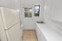 Bright, compact kitchen with white cabinets, modern appliances, and scenic window view.