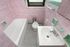 Charming vintage bathroom with pink and green tiles featuring a bathtub, classic sink, and natural light from a small window.