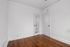 Bright, minimalistic room with elegant wood flooring and classic white trim, featuring a built-in mirrored door.