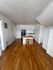 Charming kitchen with wooden floors, compact island, and cozy stools, offering an inviting space for casual gatherings.