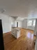 Charming kitchen area with elegant hardwood floors, bright natural light, and a practical kitchen island.