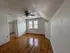 Charming room with hardwood floors, angled ceiling, and natural light from large windows.