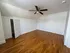 Bright and spacious bedroom with sleek wooden floors, modern ceiling fan, and classic white closet.