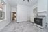 Bright kitchen with modern appliances, large windows, and sleek tile flooring, offering a spacious and airy feel.