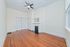 Charming living room featuring beautiful hardwood floors, a decorative fireplace, and a modern ceiling fan.