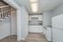 Charming kitchen with modern appliances, sleek white cabinets, and elegant wood flooring adjacent to a stylish staircase.