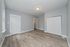 Bright and spacious room with elegant wood flooring, soft gray walls, and ample natural light from a large window.