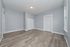 Bright and spacious room with modern wood flooring and light gray walls, featuring elegant white trim and a cozy ambiance.