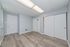 Bright and modern room with sleek wood flooring, fresh grey walls, and ample closet space.