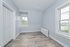 Bright, cozy room with large windows, freshly painted walls, and stylish wood flooring, highlighting serene natural views.