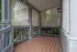 Charming screened porch with decorative lattice, inviting natural light and garden views.