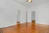 Bright room with warm wooden floors, white doors, and a ceiling fan, ideal for a cozy living space.