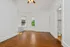 Bright room with elegant wooden flooring, large windows, and a ceiling fan, perfect for a cozy living space.