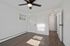 Bright and inviting empty room with sleek wooden floors, ceiling fan, and natural light streaming through a small window.