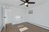 Bright, minimalist room with sleek hardwood flooring, a modern ceiling fan, and ample natural light.