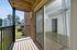 Charming balcony view with sliding glass doors leading to a bright, inviting space and scenic neighborhood backdrop.