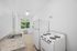 Bright and modern kitchen featuring a sleek granite countertop, classic white appliances, and a large window with a view of lush greenery.