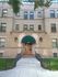 Historic brick apartment facade with green awnings and well-maintained entrance.