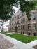 Elegant brick apartment building with lush greenery and inviting entrance.