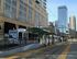 Convenient city living with a light rail stop near modern apartments and urban skyline.