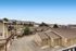 A scenic view of a cozy suburban apartment complex with surrounding mountains and expansive blue skies.
