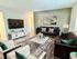 Luxurious living room featuring plush seating, a large flat-screen TV, and modern decor with green accents.