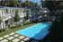 Serene apartment complex with a sparkling pool and lush greenery.
