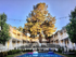 Serene courtyard featuring a sparkling pool, surrounded by two-story apartment buildings and lush greenery.