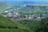 Aerial view of a vibrant city surrounded by lush green hills and a sprawling landscape.