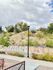 Charming hillside with artistic mural and lush greenery under a cloudy sky.