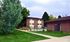 Serene apartment complex with lush greenery and outdoor pool.