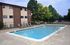 Inviting swimming pool in a residential complex with lounge chairs and lush greenery.
