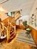 Inviting entryway with classic wooden staircase, plush carpeting, and cozy seating area.