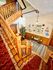 Inviting entrance featuring a classic wooden staircase with ornate railings and a cozy seating area.